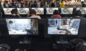 room of people playing video games on screens