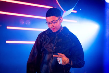 Kwn on a dark stage with strobe-style lighting in the background