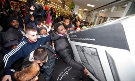 A crowd of people fight over a giant TV