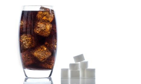 A glass of cola and some sugar cubes
