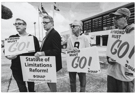 Members of the Survivors Network of those Abused by Priests (Snap), including Kevin Bourgeois, left, John Gianoli, Richard Windmann, and John Anderson, hold signs outside the New Orleans Saints training facility in Metairie, Louisiana, in 2020. SNAP is demanding that Gayle Benson, the owner of the NFL Saints and NBA Pelicans, release all emails where the Saints provided public relations assistance to the Catholic Archdiocese of New Orleans regarding clergy sexual abuse cases. The sign “Aymond Must Go!” refers to New Orleans Archbishop Gregory Aymond while Gianoli holds a sign asking for statute of limitations reform since he was a child when he was abused and didn’t report the abuse till years later.