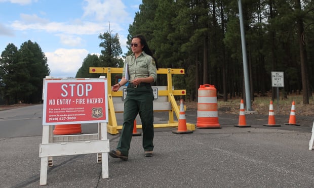 Coconino national forest employee Amber Wong checks a road sign outside Flagstaff, Arizona, announcing the closure of the park amid extreme wildfire danger. 