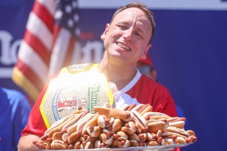 Joey Chestnut proudly holds up a plate of hotdogs after winning Nathan’s Famous Fourth of July hotdog eating contest in Brooklyn, New York.