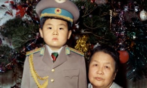 Kim Jong-nam as a young child dressed in an army uniform poses with his maternal grandmother.