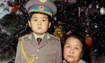 Kim Jong-nam as a young child dressed in an army uniform poses with his maternal grandmother.