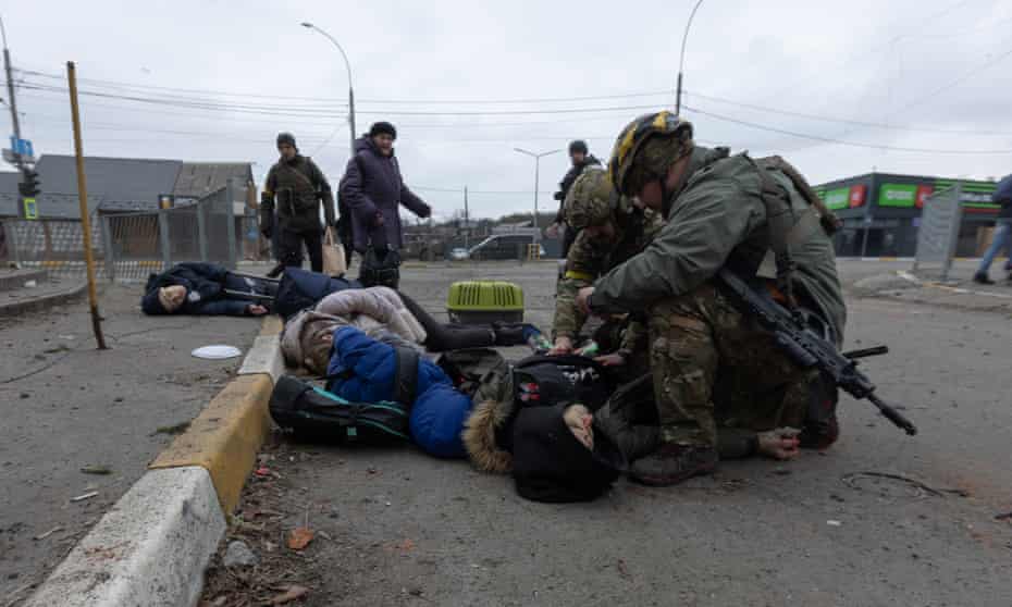 Ukrainian soldiers try to aid the victims of a mortar attack from Russian forces