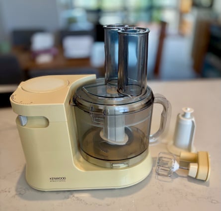 A cream coloured plastic mixer with a smoke-grey mixer jug and attachment