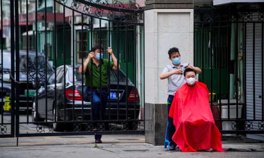 A resident gets a haircut on a street in Shanghai.