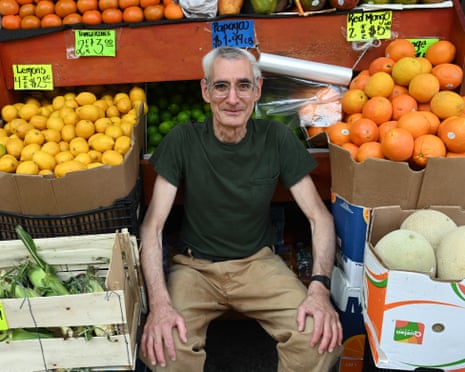 A man sitting among fruit and veg
