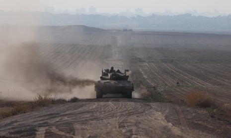 An Israeli tank moves along the border with Gaza in southern Israel on Sunday