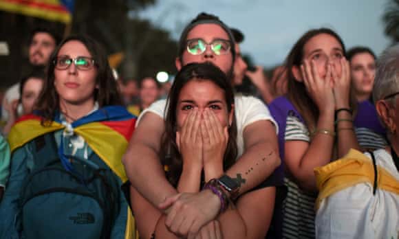 Pro-independence supporters react as they watch on broadcast screens outside the Catalan parliament