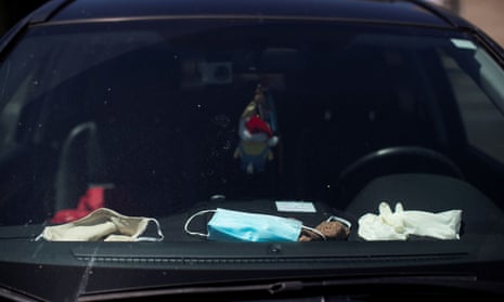 Face masks and gloves on the dashboard of a vehicle during the coronavirus disease outbreak