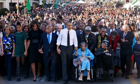 Barack Obama holds hands with Amelia Boynton as they cross the Edmund Pettus Bridge in Selma on 7 March 2015.