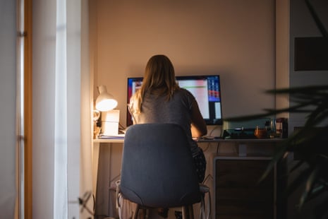 Rear view of woman working late at computer at home