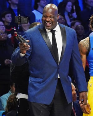 Shaquile O'Neal smiles into a phone he holds on a selfie stick