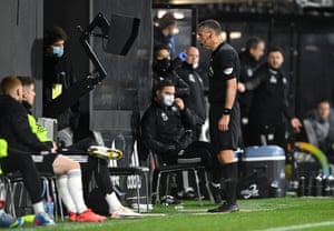 Referee Andre Marriner reviews the pitchside monitor for a VAR check and decides otherwise