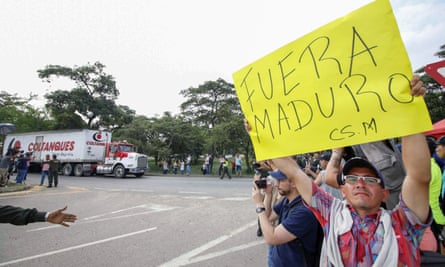 A demonstrator in Cúcuta welcomes aid trucks with a placard saying ‘Maduro out’.