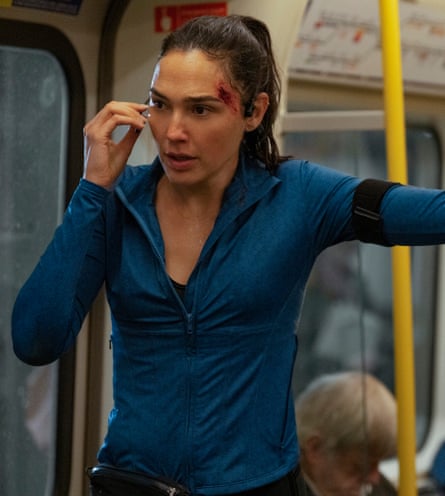 Woman with hair pulled back and a blue top in a train