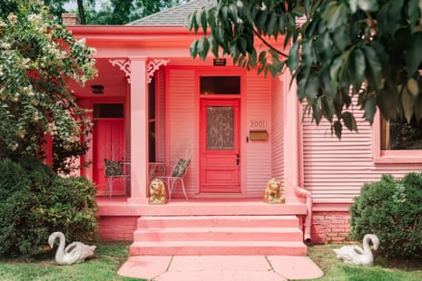 bright pink exterior of house with front porch surrounded by trees