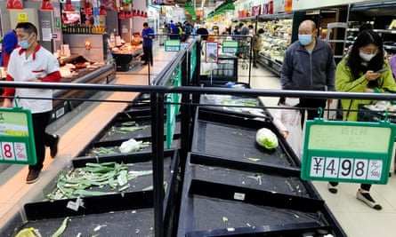 Customers shop at a supermarket with near-empty shelves in Beijing following a Covid outbreak in the Chaoyang district.