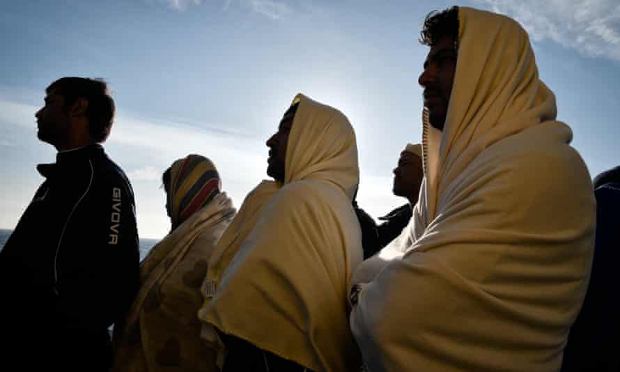 Migrants in blankets on boat