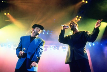 Elton John and George Michael on stage under coloured lights