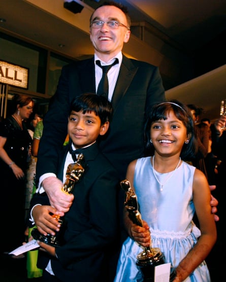Danny Boyle poses with young actors and two of Slumdog Millionaire’s eight Oscars.
