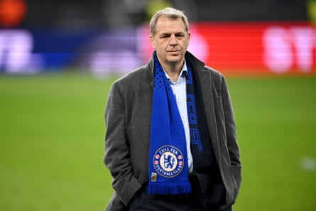 Boehly on the pitch in a suit, wearing a grey woollen jacket and a Chelsea scarf around his neck