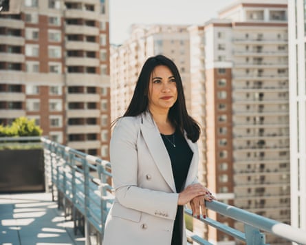 Jessica Miller on large balcony overlooking high-rise buildings