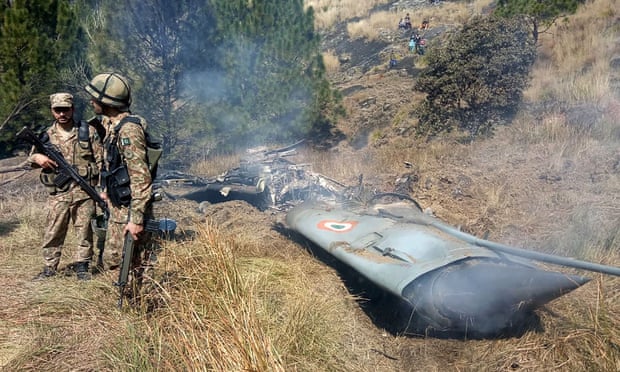 Pakistani soldiers stand next to what Pakistan says is the wreckage of a shot down Indian fighter jet in Pakistan-controlled Kashmir.