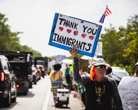 Protesters gather at on the road near ‘Alligator Alcatraz’ one holds a sign that says ‘Thank you immigrants.’