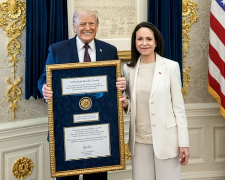 Donald Trump holding the framed peace prize stood alongside María Corina Machado