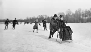 black and white photo of people skating on ice outside