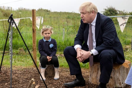 Boris Johnson visits a primary school with an angry looking small child