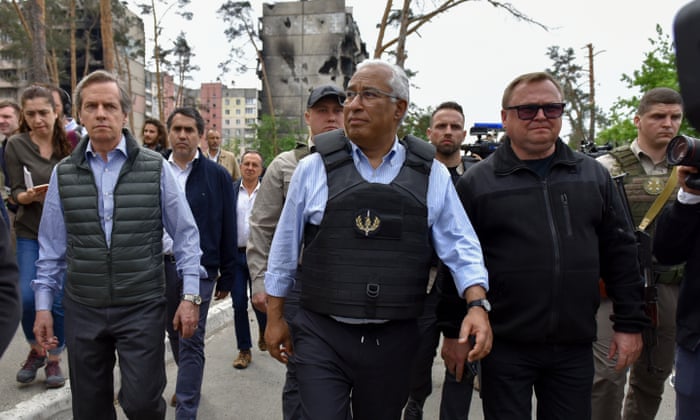 The Portuguese prime minister, António Costa, looks at damaged buildings during his visit to Irpin on Saturday.