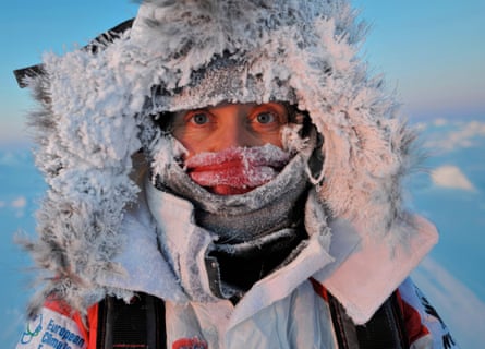 A woman so wrapped up in a jacket with frozen fur around her face that you can only see her eyes