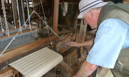 Ron Stewart examining a loom as he travelled the world looking for rugs and textiles, which he imported to the UK