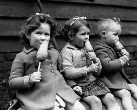 Three young children enjoying a portable, healthy snack – a carrot on a stick