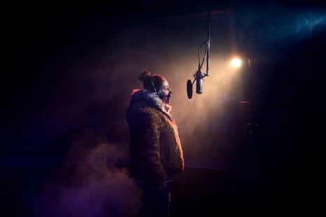 A woman stands before a recording microphone