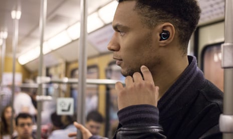 a man on the tube wearing bragi the dash earpieces