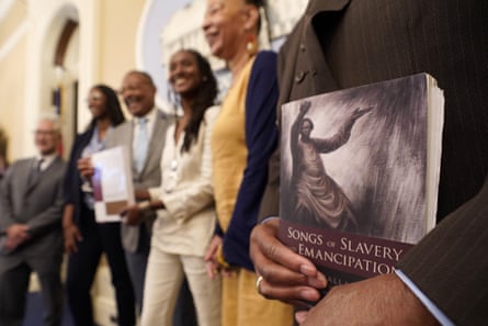 Dr Amos C Brown, Jr, vice-chair for the California reparations task force, holds a copy of the book Songs of Slavery and Emancipation.