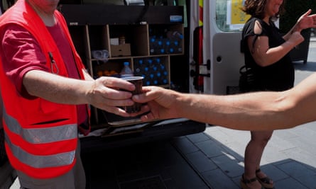 Red Cross workers hand out water to homeless people in Tours amid sweltering conditions.