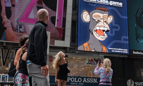 People take photos by a Bored Ape Yacht Club NFT billboard in Times Square in New York City.
