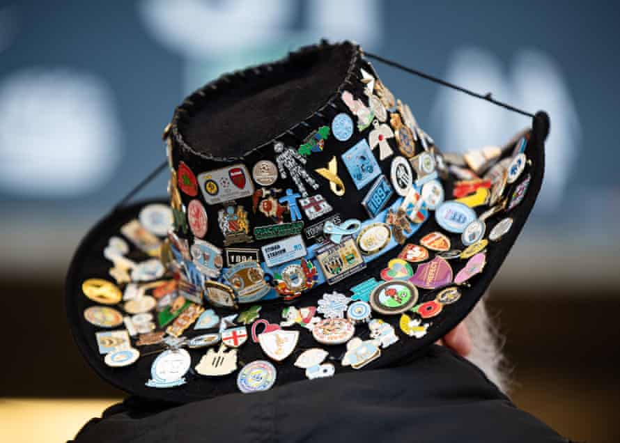 Cap decorated with a Manchester City fan badge.