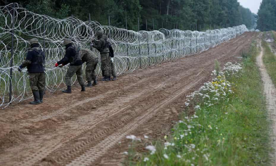 Polish soldiers build a fence on the border with Belarus.