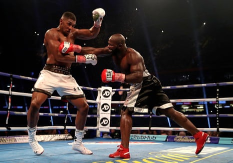 Anthony Joshua takes evasive action as Carlos Takam fights back.