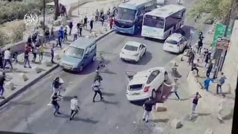 Israel: car hits Palestinian protesters after being pelted with stones – video