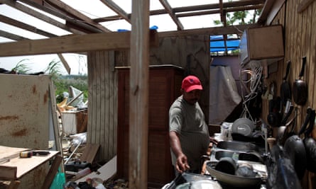 A man in Puerto Rico sorts through the remains of his home.