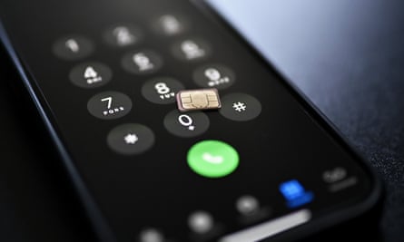 A sim card lying on the screen of a smartphone.