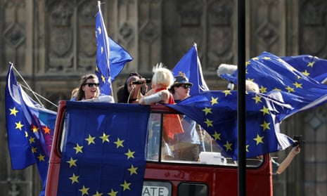 Anti-Brexit demonstrators wave EU flags on a bus driving by Parliament Square